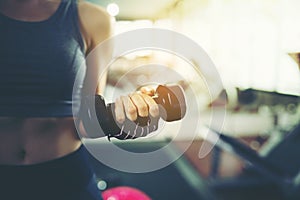 Woman holding dumbbell in the fitness gym