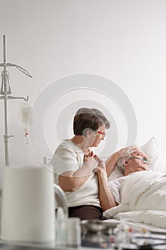 Woman holding dying husband`s hand