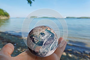 Woman holding Earth globe in the palm of her hand