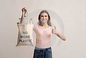 Woman Holding Eco Bag With Empty Bottles And No More Plastic Inscription