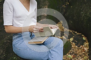 Woman holding educational books in a park