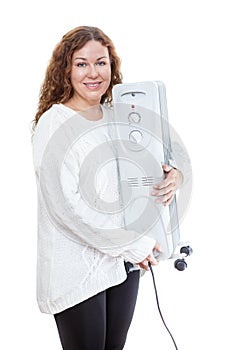 Woman holding electric oil radiator in hands isolated on white background