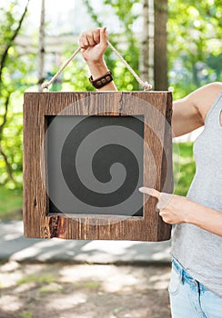 Woman holding empty blackboard with wooden frame. Template Mock