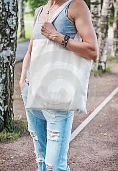 Woman holding empty canvas bag. Template mock up