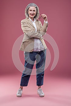 Woman holding eyeglasses and having a thoiughful look