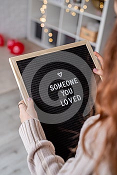 Woman holding felt letter board with the words Someone You Loved