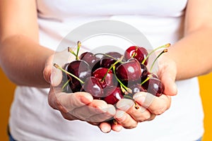 Woman is holding few sweet red cherry in his hand's