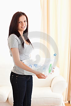 Woman holding filled recycling bin