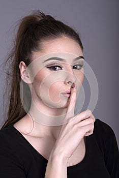 Woman holding finger over her mouth