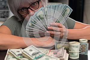 Woman holding a fistful of 100 dollar bills