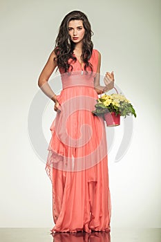 Woman holding flower basket and pulls up her red dress