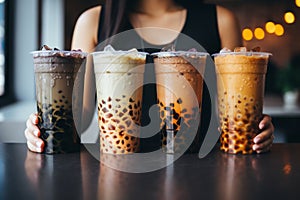 Woman holding four different types of bubble tea, boba tea asian trendy beverage