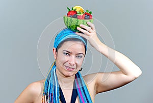 Woman holding fruit bowl over head