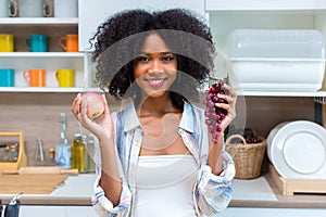 Woman holding fruit in kitchen room. woman on a diet, a woman vegetarian prepares a eat fruit