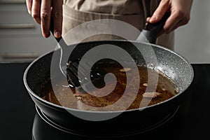 Woman holding frying pan with used cooking oil