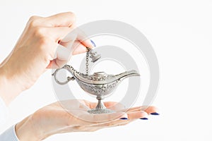 Woman holding genie lamp, hoping for a miracle from the magic spirit