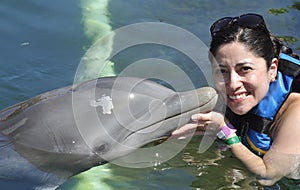 Woman holding a kiss from a dolphin.