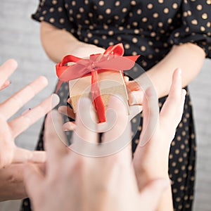 Woman holding a gift box tied with a red ribbon