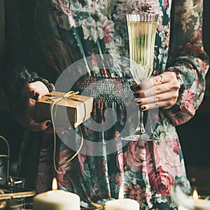 Woman holding glass of champaigne and gift box during Christmas