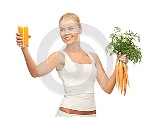 Woman holding glass of juice and carrots