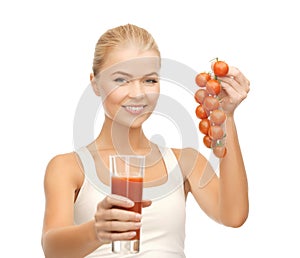 Woman holding glass of juice and tomatoes