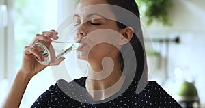 Woman holding glass of natural water drinking aqua reducing thirst