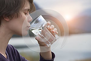 Woman holding glass of pure mineral water and drinking
