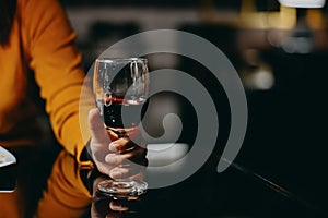 Woman holding a glass of re wine with vintage tone