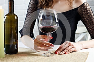 Woman holding a glass of red blue waiting for man