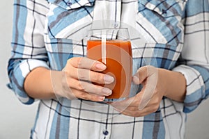 Woman holding glass of tasty carrot juice