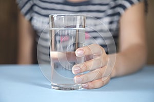 Woman holding glass of water