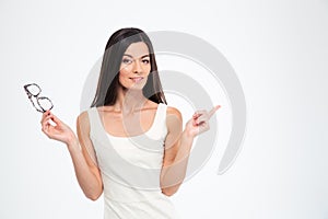 Woman holding glasses and pointing finger away