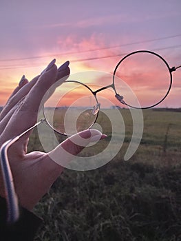 Woman holding glasses sunsets field view landscape purple yellow nature