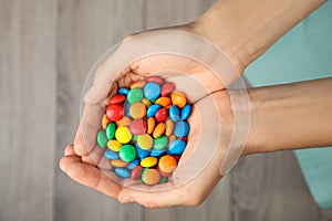 Woman holding glazed candies on blurred background