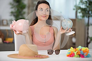 woman holding globe and piggybank