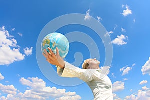 Woman holding a globe under sky