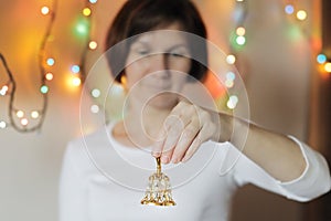 Woman holding a golden handbell (xmas decoration)