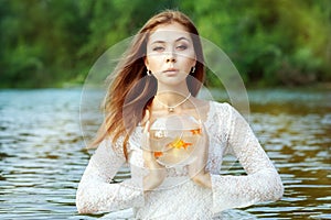 Woman is holding a goldfish in an aquarium.