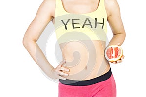 Woman holding a grapefruit next to the waist. Diet and proper nu