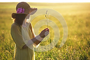 Woman holding grass plant in summer field