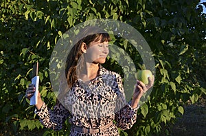 Woman holding a green apple and a chocolate choosing between it. Vegetables or sweets