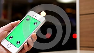 Woman holding green screen cell phone on beautiful blurred lighting background
