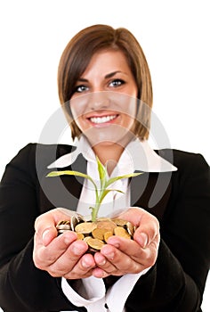 Woman holding a growing plant and coins