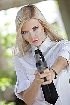 Woman holding gun in blouse and tie