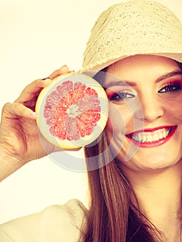 Woman holding half of grapefruit citrus fruit in hand