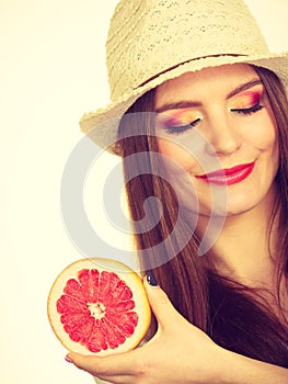 Woman holding half of grapefruit citrus fruit in hand