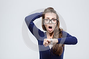 Woman holding hand with wrist watch and looking at camera