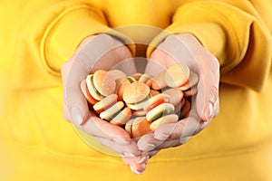Woman holding handful of delicious gummy burger shaped candies, closeup