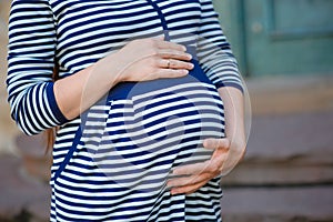 Woman holding hands on her pregnant belly