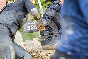 Woman holding hands in mud.